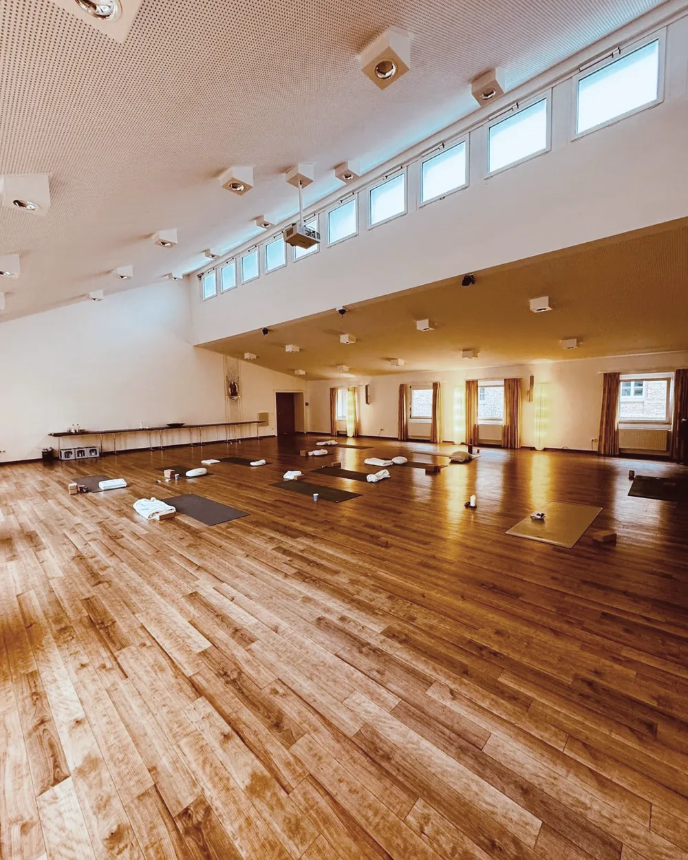 Großer lichtdurchfluteter Retreat-Raum mit Kerzen und Yogamatten im Kloster Arenberg
