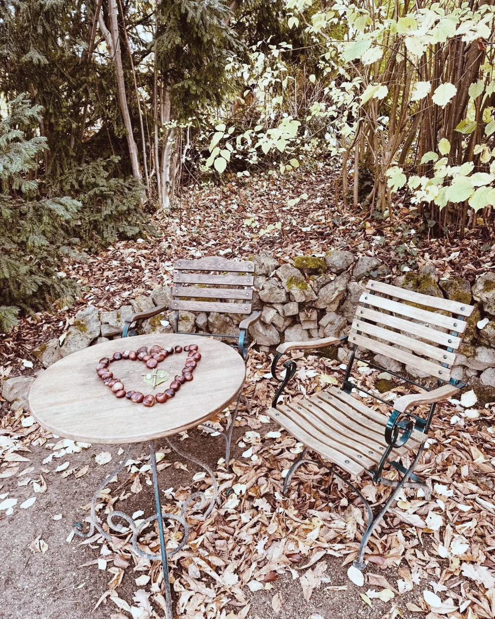 Herz aus Herbstlaub vor einer Bank – achtsamer Moment beim Yoga-Retreat