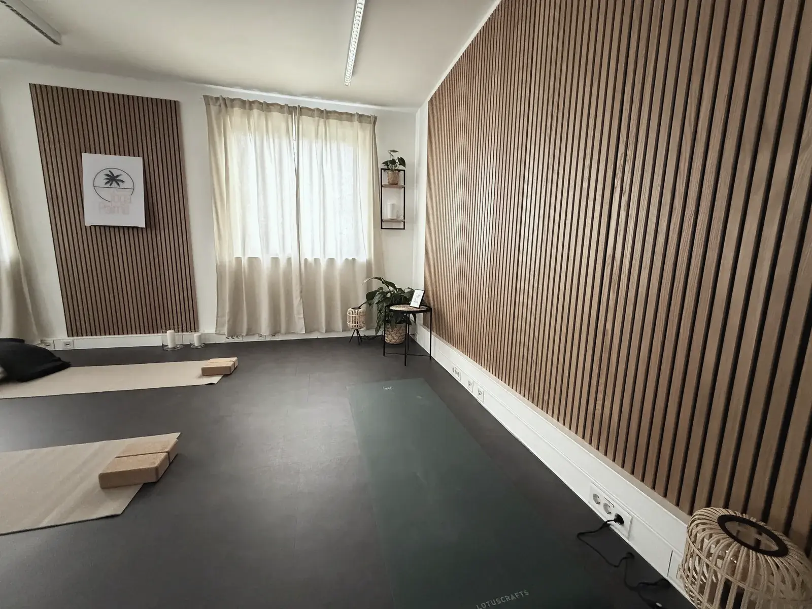 Yoga Palme Studio – Akustik-Holzwand und warme Beleuchtung